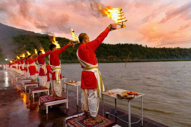 Rishikesh, Uttarakhand - August 03 2016: Priests in red robe in the holy city of Rishikesh in Uttarakhand, India during the evening light ceremony called Ganga arthi to worship river Ganga / Ganges.